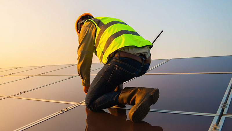 ein Mann arbeitet an einem Solarpanel